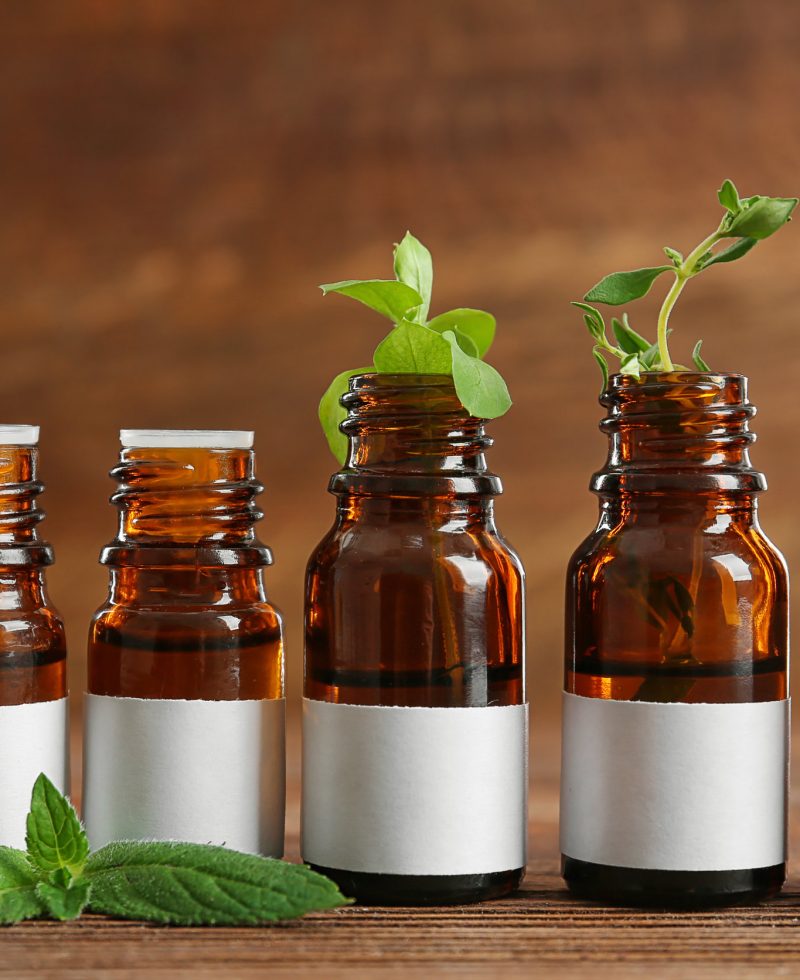 Dropper bottles and herbs on wooden table